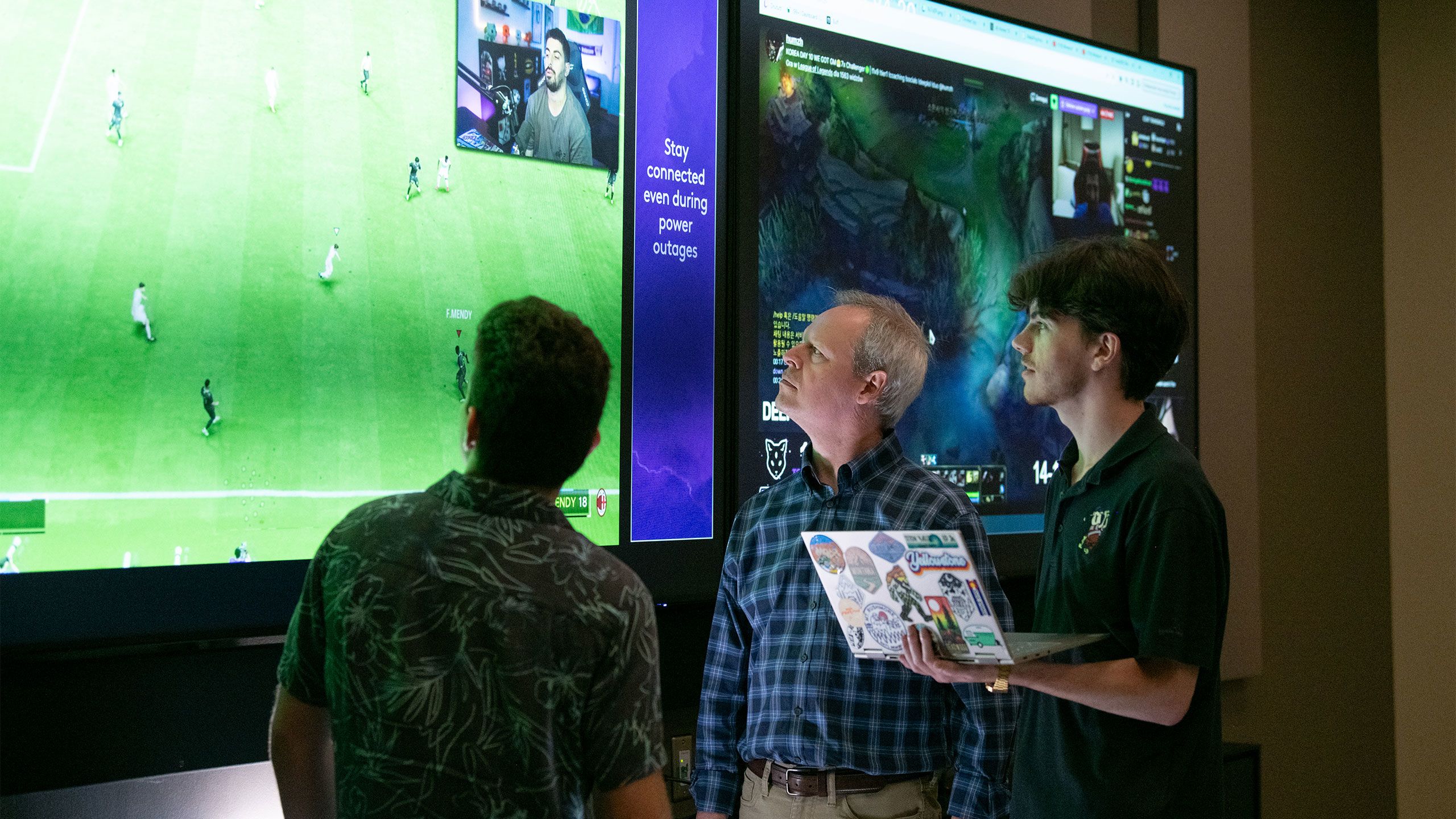 Mike Little and a student watch a twitch stream on a lab monitor